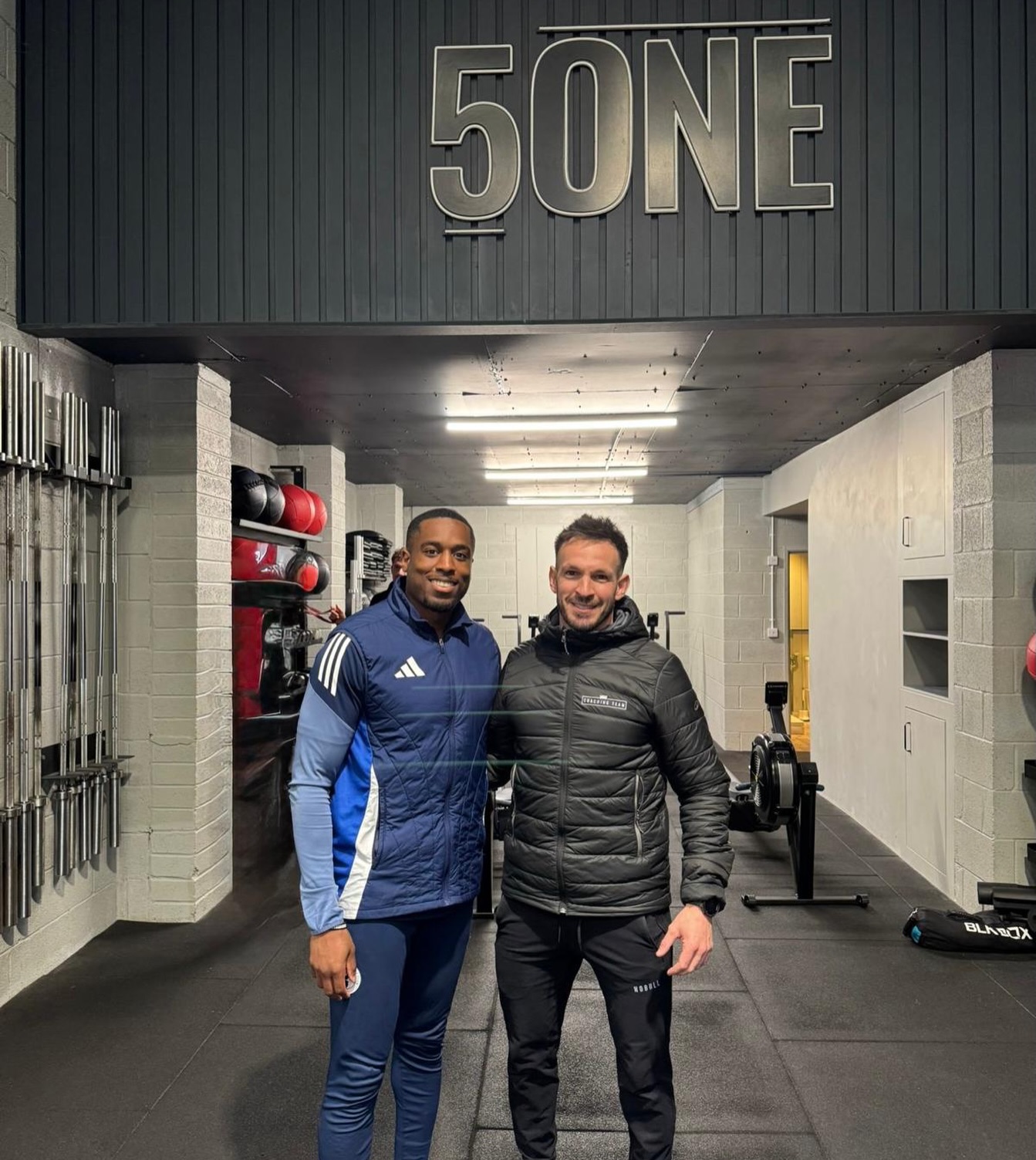 Dom with a colleague under the 5ONE sign in the 5ONE Fitness gym