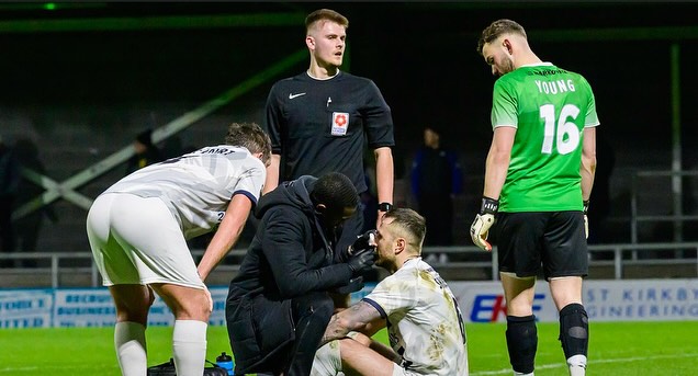 Dom treating a player during a floodlit match