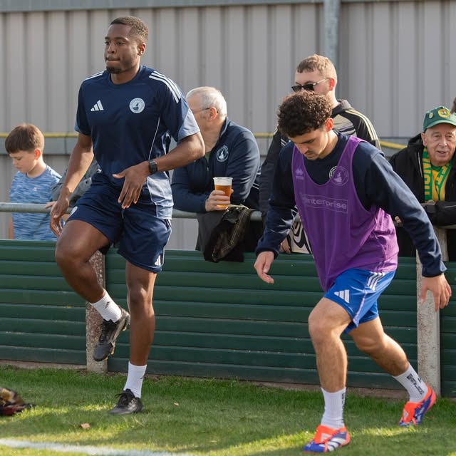 Dom leading a pitch-side warm-up with a player
